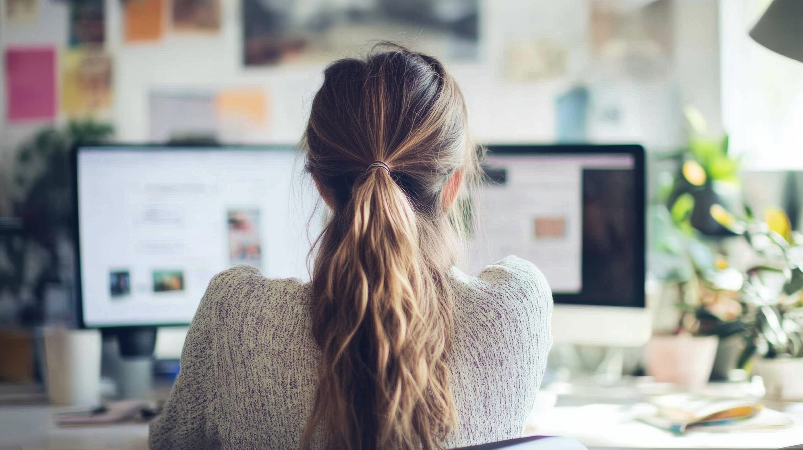 A freelance designer working remotely, finalizing a website template and digital marketing strategy in a bright, modern workspace